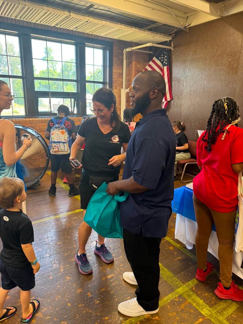Leon speaking with families at a community event